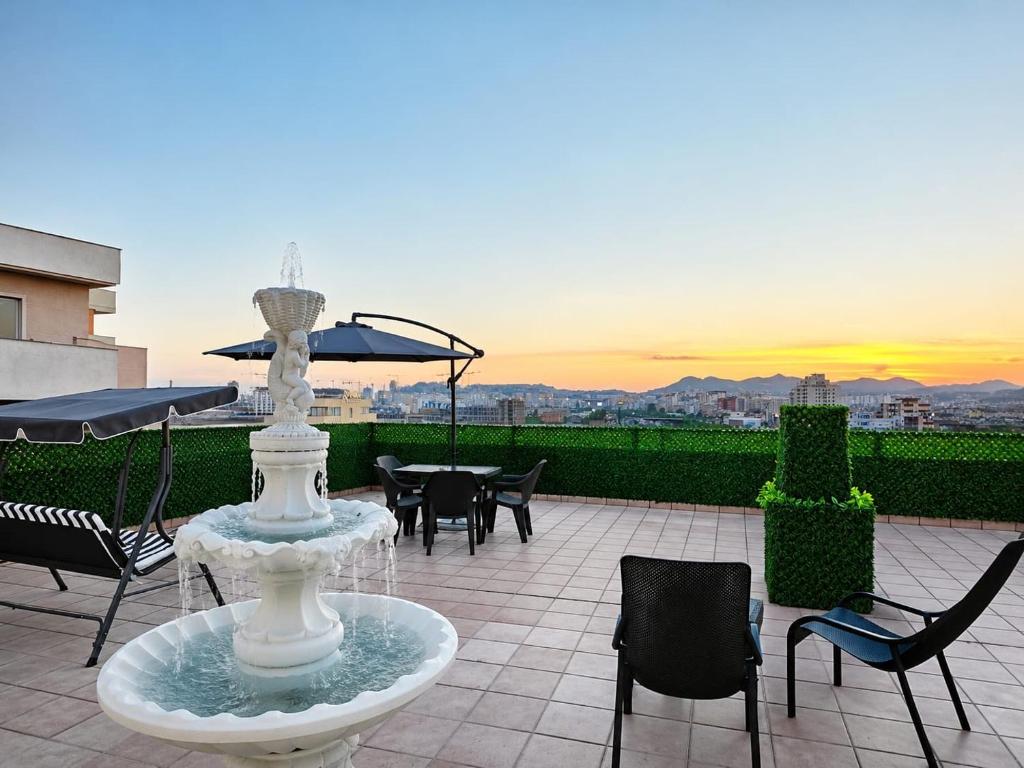 a fountain on a patio with chairs and a table at Voyyo Skyline in Durrës
