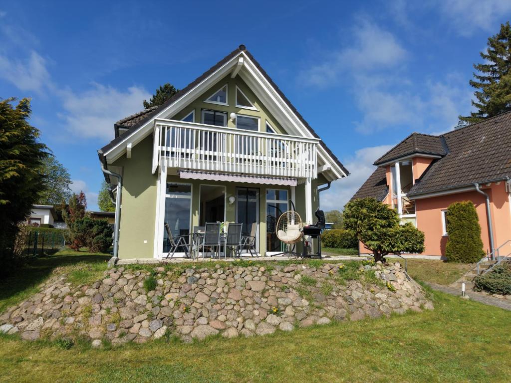 a house with a porch and a stone wall at Ferienhaus Seestern direkt am Plauer See in Plau am See