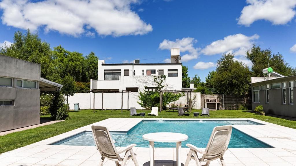 a backyard with a pool and a table and chairs at La Cañada Chascomús in Chascomús