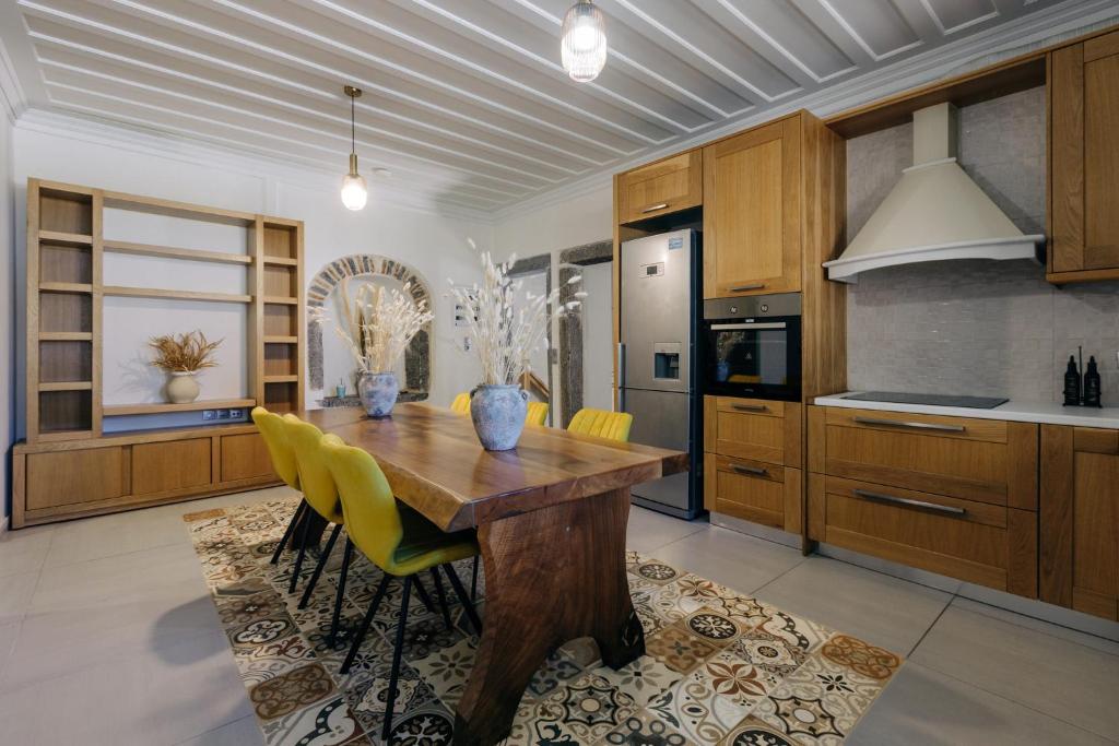 a kitchen with a wooden table and yellow chairs at Mesta Grand Residence in Chios