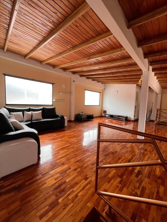 a living room with a couch and a wooden ceiling at Refugio de Guacamayas in Mérida