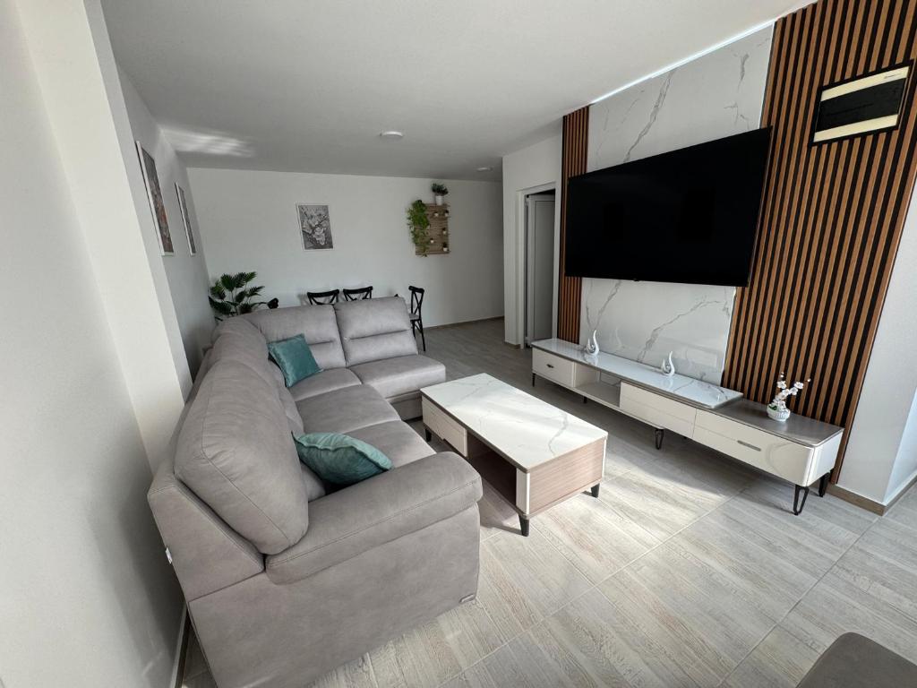 a living room with a couch and a flat screen tv at Andrej Apartmani Rafailovici in Rafailovici