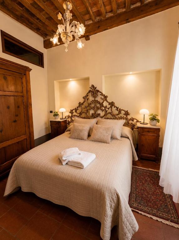 a bedroom with a large bed with two towels on it at Le Dimore della Seta - Palazzo Busdraghi in Lucca