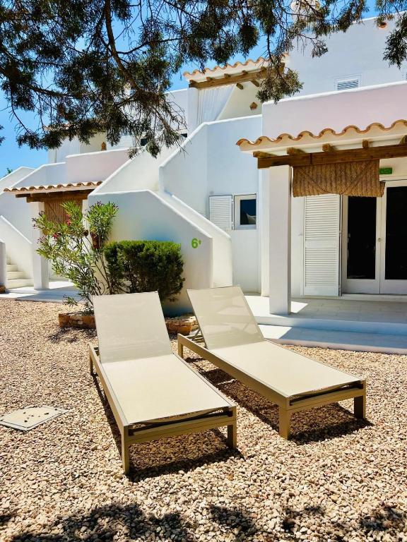 two lounge chairs and a table in front of a house at Can Chumbera Formentera in Cala Saona