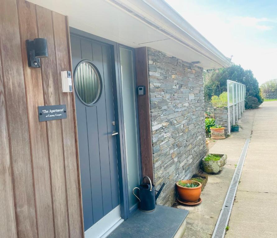 a blue door on the side of a house at The Apartment at Estuary Escapes in Kingsbridge