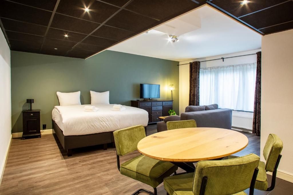 a hotel room with a bed and a table and chairs at Hotel de Duif Lisse - Keukenhof in Lisse
