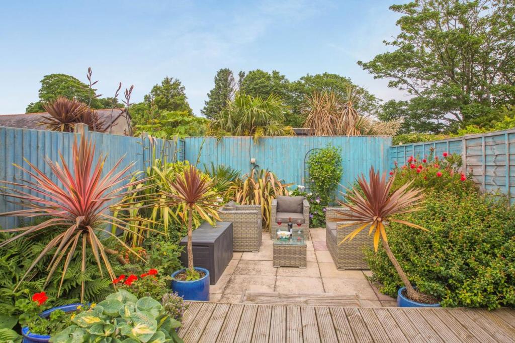 a garden with potted plants and a blue fence at 2 Bed in Pwllheli oc-44492 in Nefyn