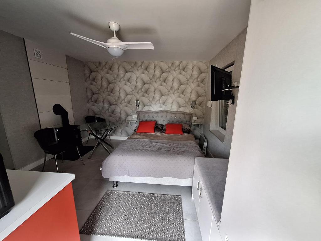 a bedroom with a bed with red pillows and a ceiling at Domek Za Wyspą 3 in Chmielów