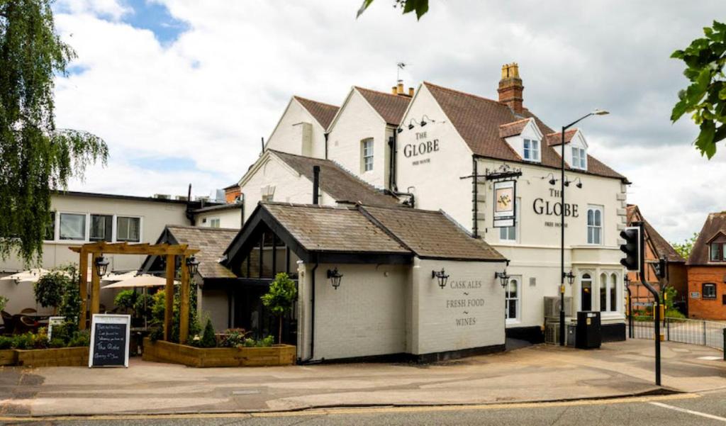 a white building in front of a building at The Globe, Warwick, Warwickshire - Brunning & Price in Warwick