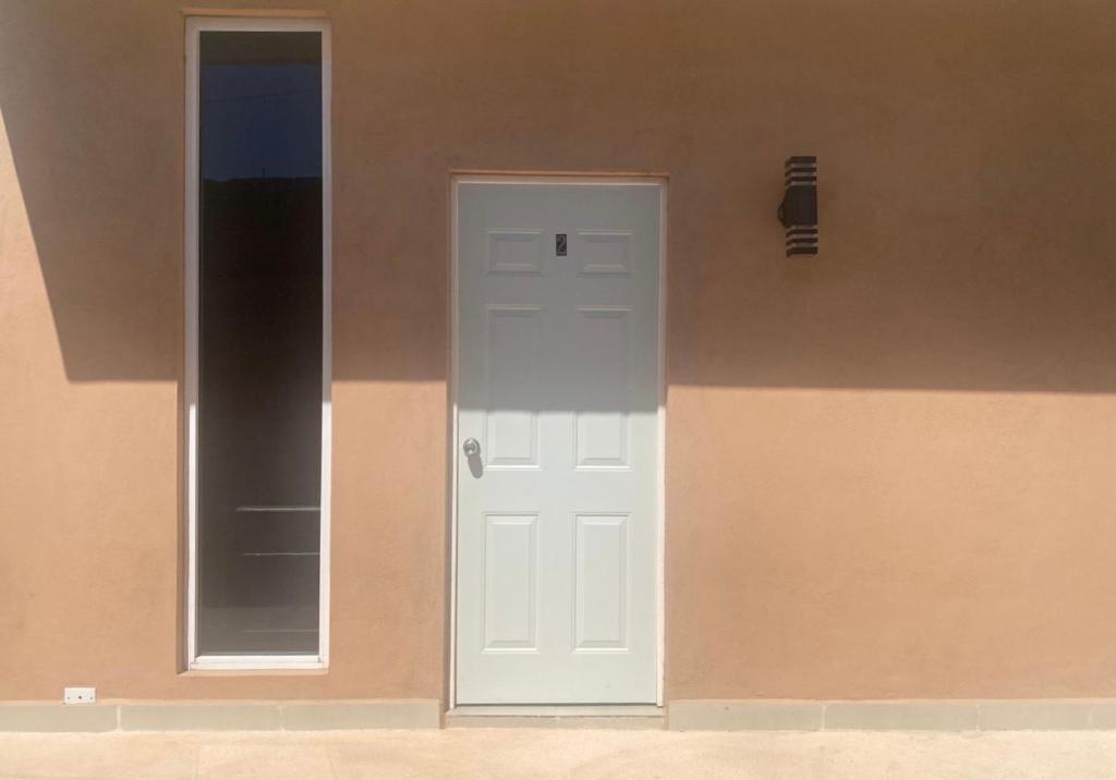 a white door and a mirror on the side of a building at Studio Cangrejos in Los Médanos Partidos