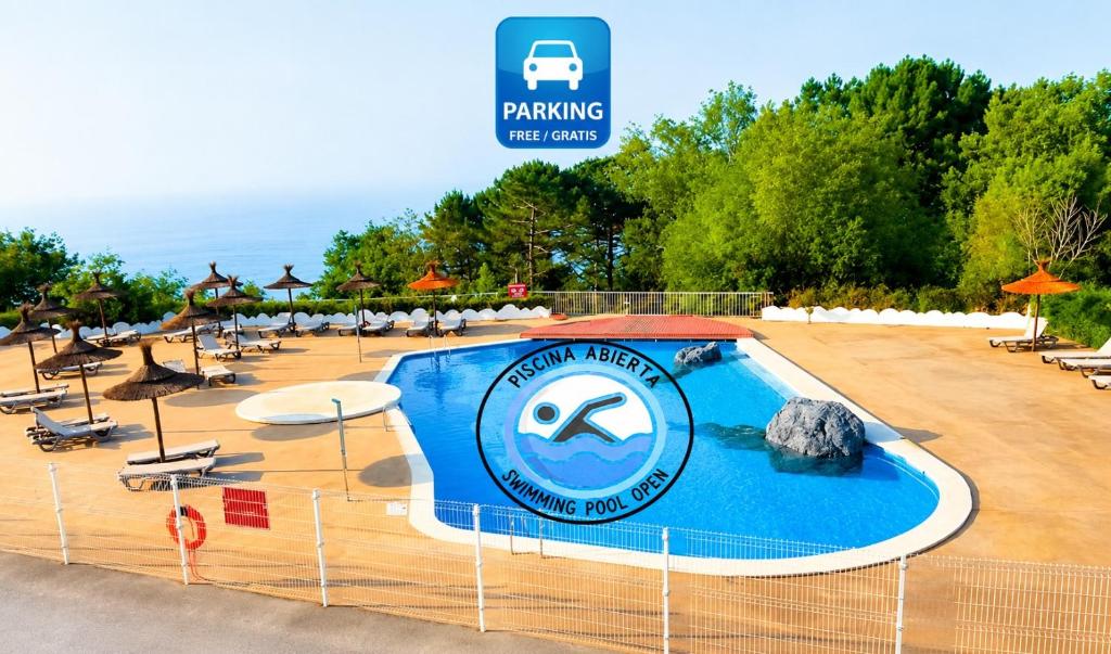 a swimming pool at a resort with a sign on it at Hotel Gudamendi in San Sebastián