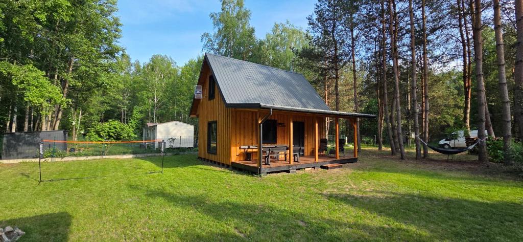 a small cabin in the middle of a yard at Leśne Zacisze 4 in Łuka