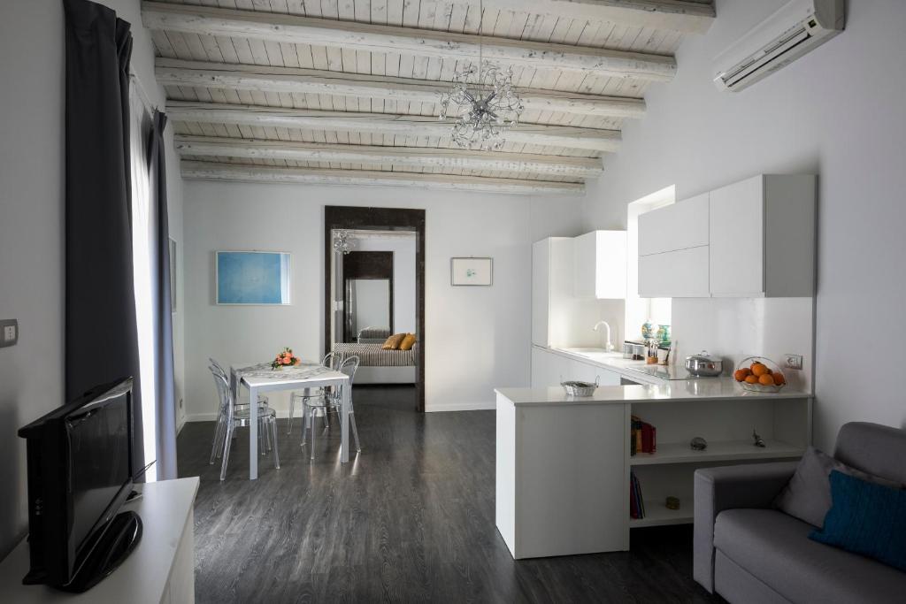 a white kitchen and living room with a table at Casa Matteotti in Modica