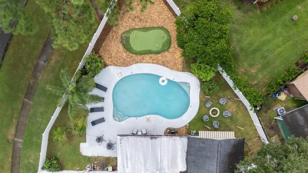 an overhead view of a swimming pool in a yard at Putt Putt Pool Home - Mini Golf Grill Ping Pong in Jacksonville
