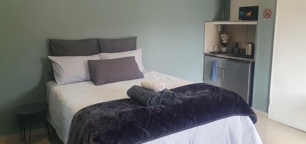 a bed with two pillows on it in a bedroom at MERK Guest House in Piet Retief