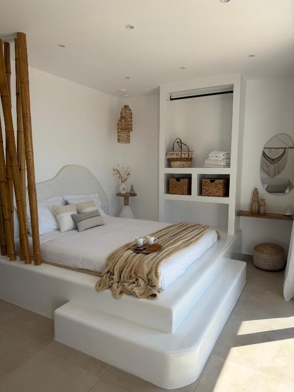 a white bedroom with a large white bed in it at Patela Luxury Suites in Panormos Kalymnos