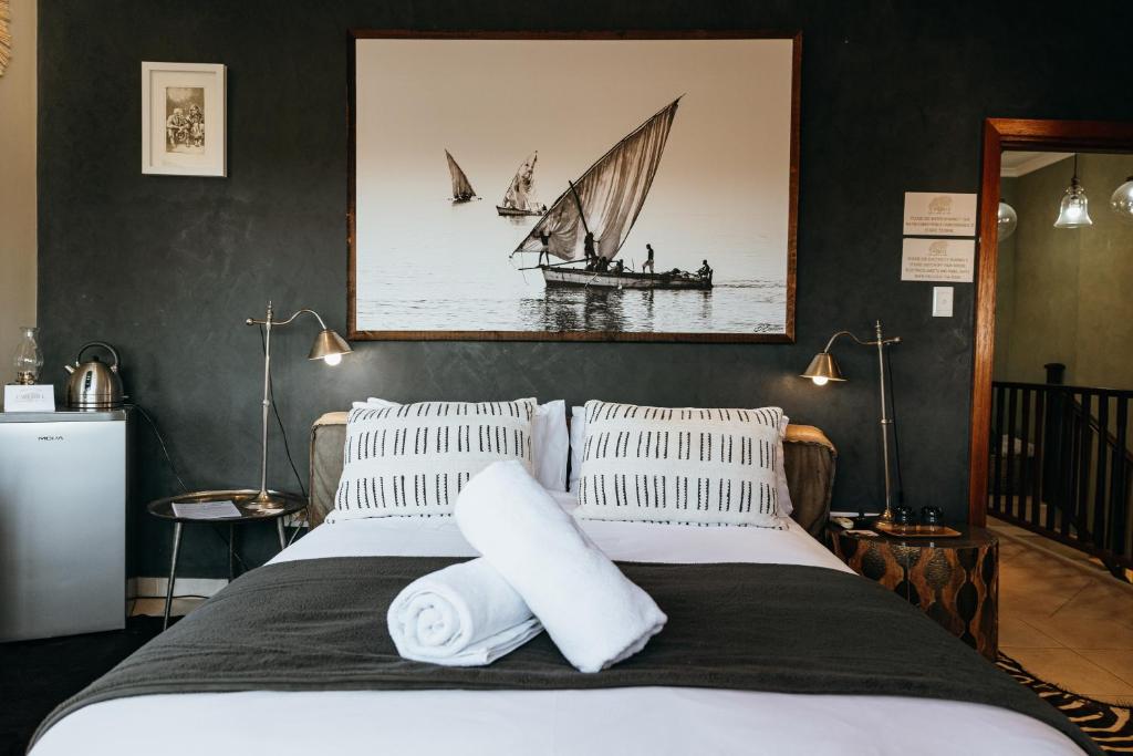 a bedroom with a bed with a sail boat on the wall at Cwebile Guesthouse in Winterton