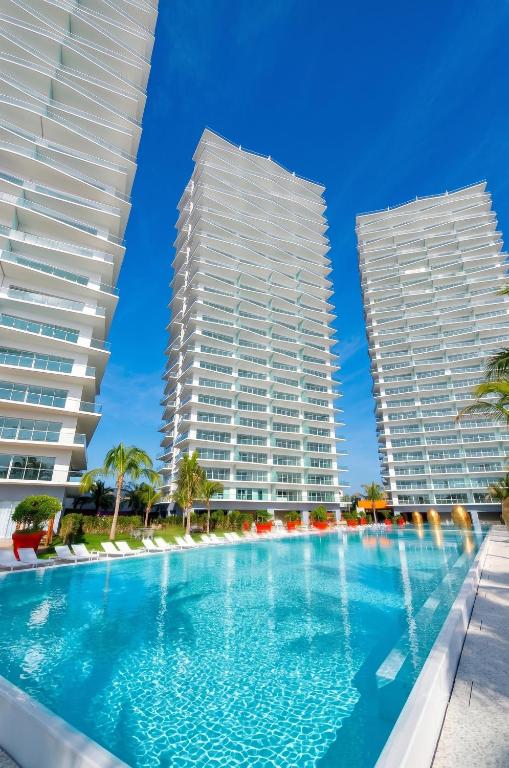 two towers with a swimming pool in front of two buildings at ICON Oceanview Retreat by Monyxbnb in Puerto Vallarta