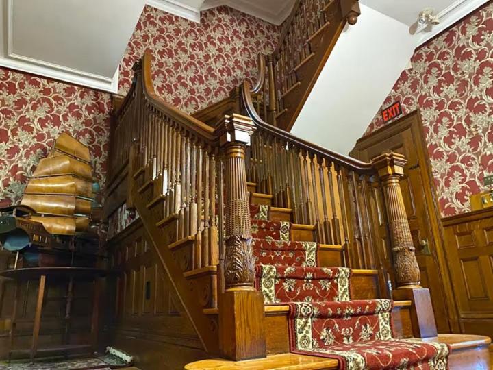 a wooden staircase in a room with red wallpaper at Fenway Park Brownstone in Boston