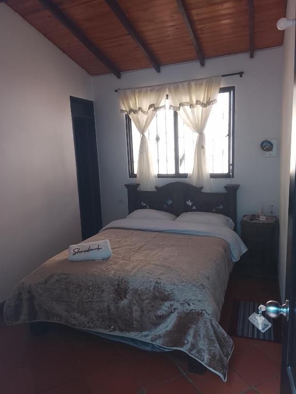 a bedroom with a large bed and a window at Hostal familiar Shambala in Silos