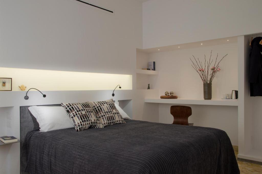 una camera con letto, sedia e scaffali di Limen Matera Guesthouse a Matera