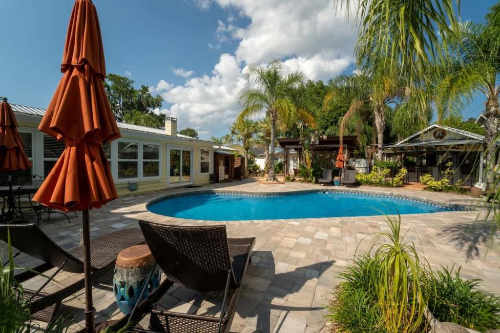 a swimming pool with two chairs and an umbrella at The Poolside Cottage -Wifi Pool in Jacksonville