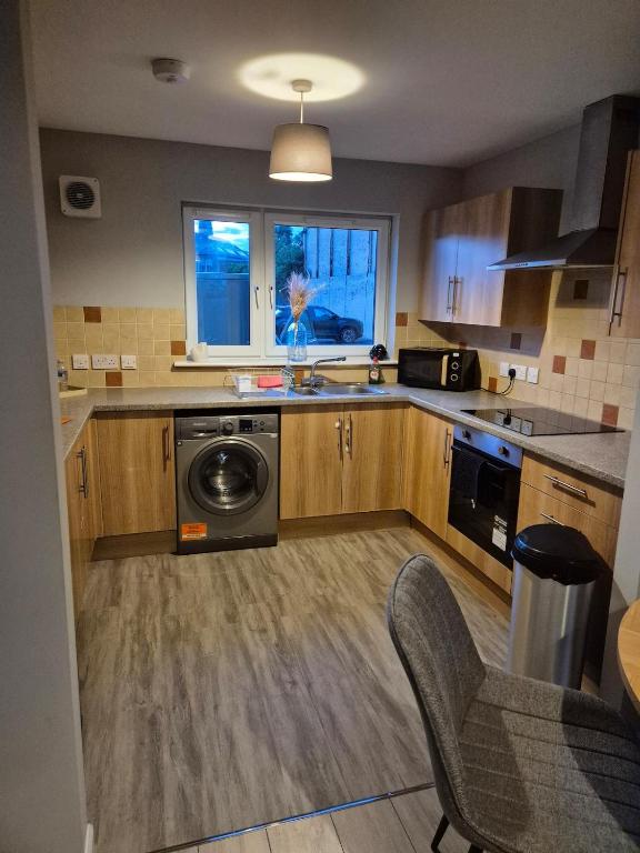 a kitchen with a sink and a washing machine at Bellfield Views in Dundee