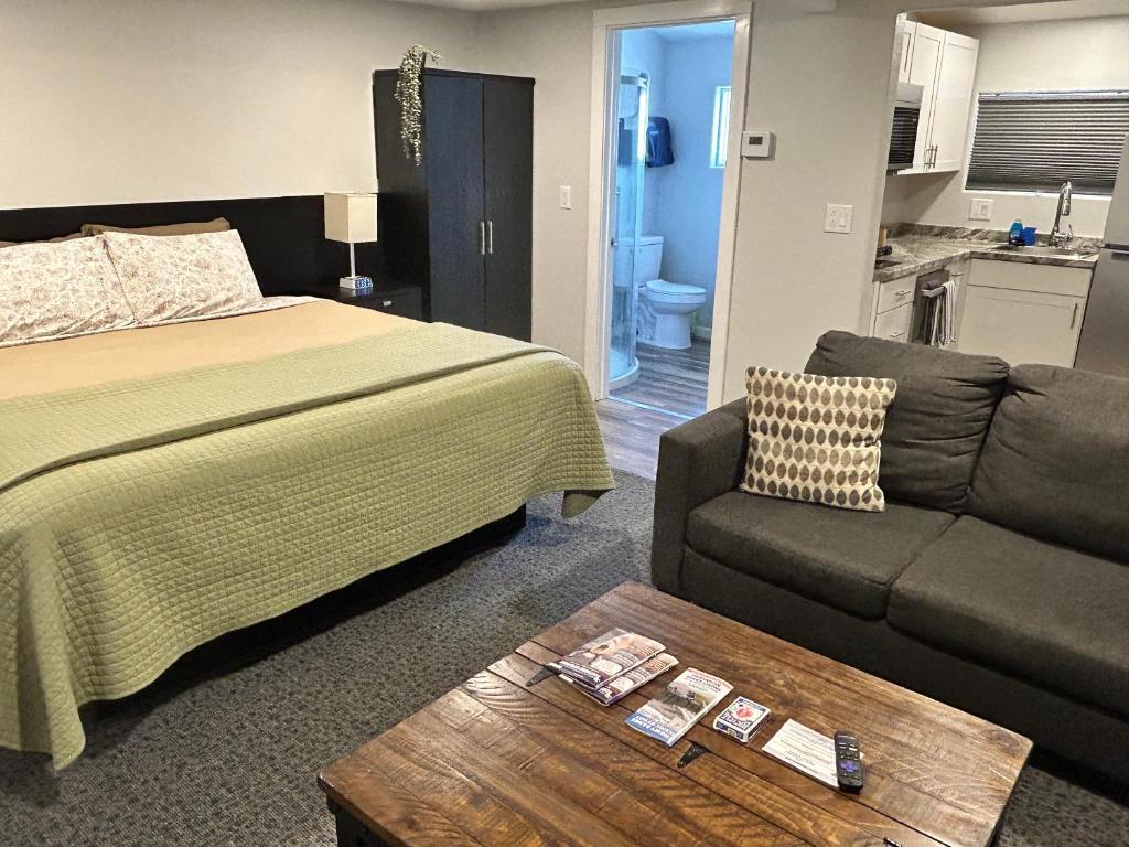 a bedroom with a bed and a couch and a table at Snowy Mountain Inn in Saratoga
