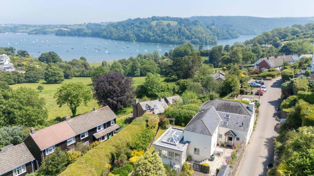 an aerial view of a village with a river and houses at Dart View Cottage - A Stunning Riverside Escape in the Heart of South Devon in Dittisham