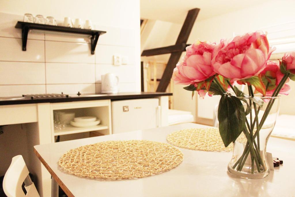 a vase of pink flowers on a table in a kitchen at Ubytování U Vojtěšky in Pasohlávky