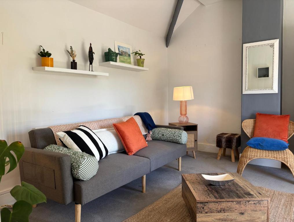 a living room with a couch and a table at Stylish Countryside Loft near Silverstone-Bicester in Buckingham