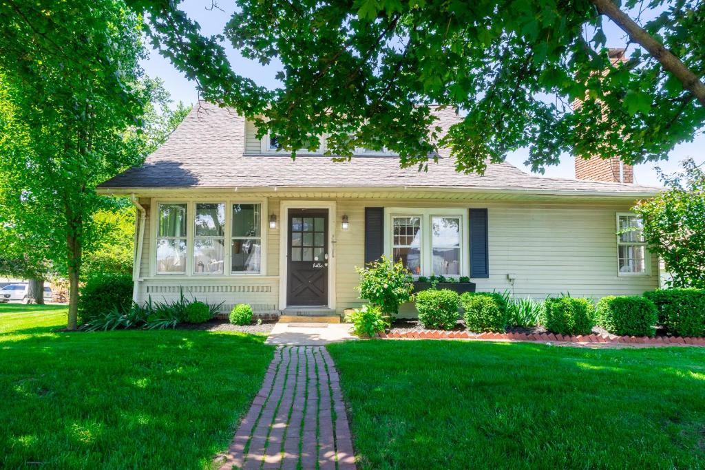 a house with a brick walkway in front of a yard at The Berlin Guesthouse in Millersburg