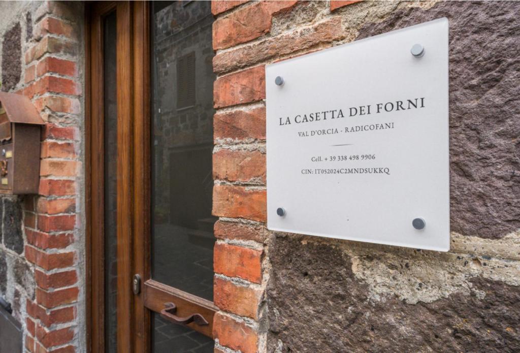 a sign on the side of a brick building at La Casetta dei Forni in Radicofani