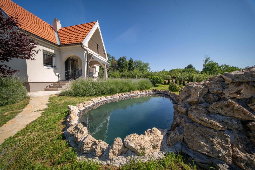 a swimming pool with a rock wall next to a house at Casa Frida in Manđelos