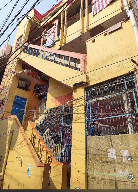 a yellow building with a gate on the side of it at Peddanna House Complex in Vijayawāda