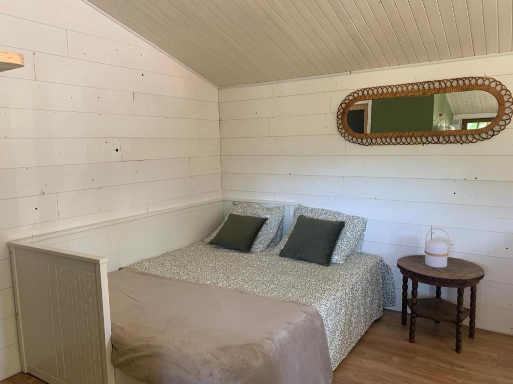 a room with a bed with a mirror and a table at Chalet bucolique in Saint-Étienne-de-Chigny