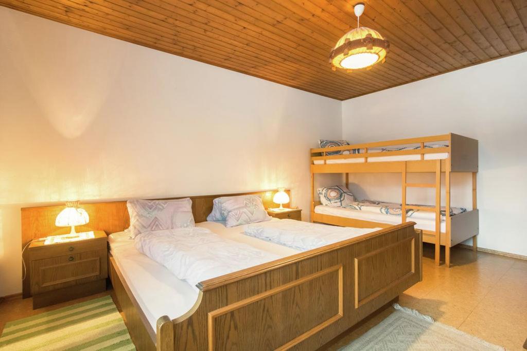 een slaapkamer met een bed en een stapelbed bij Haus Osterrieder in Sankt Michael im Lungau