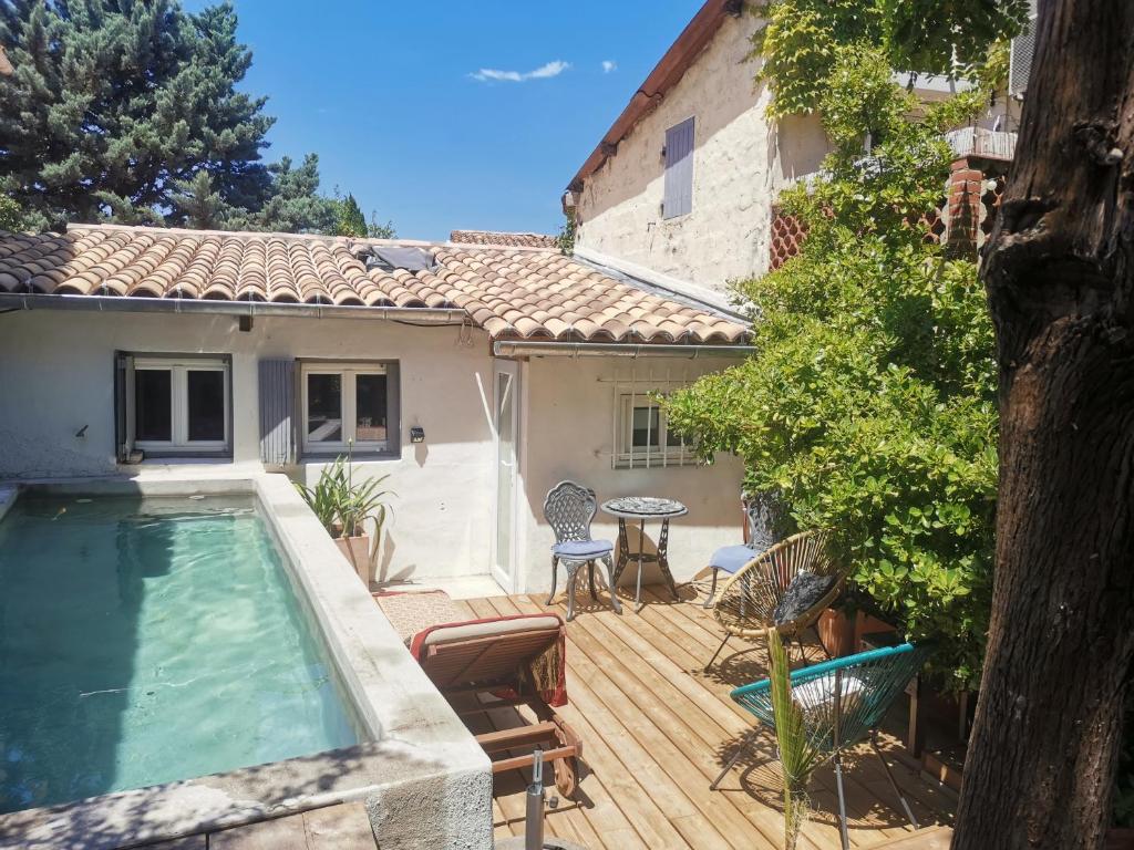 a house with a swimming pool on a wooden deck at Casa d'Olivier chambre d'hôtes in Arles