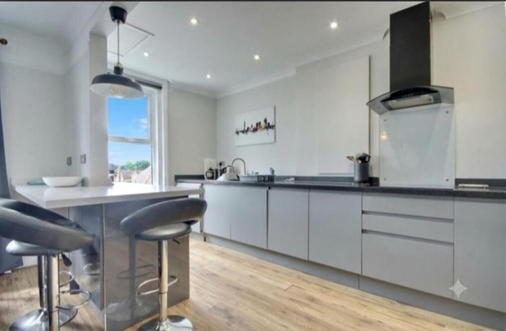 a kitchen with white cabinets and black counter tops at Lennox Lodge 2 in Portsmouth