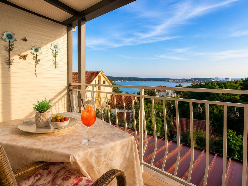 a table on a balcony with a view of the water at Apartment RB in Omišalj