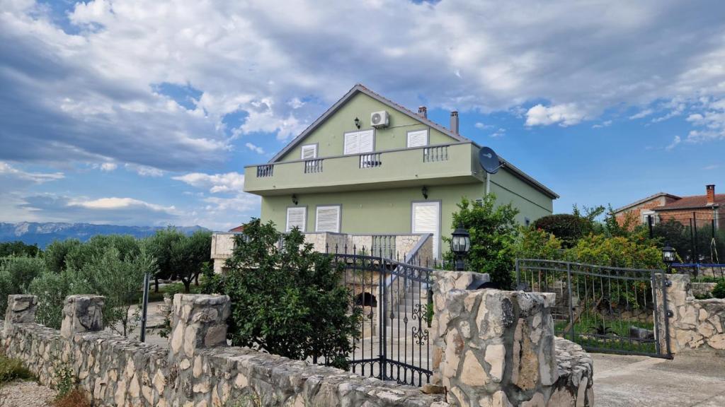 a green house with a fence in front of it at Villa Eagle in Benkovac
