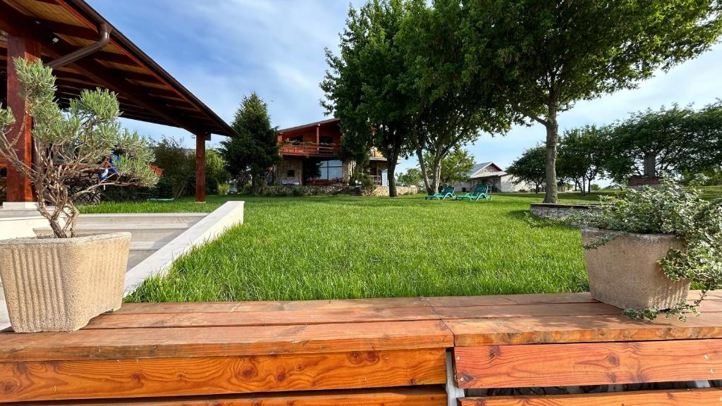 a wooden deck with two potted plants in a yard at Casa Maria in Vrancea