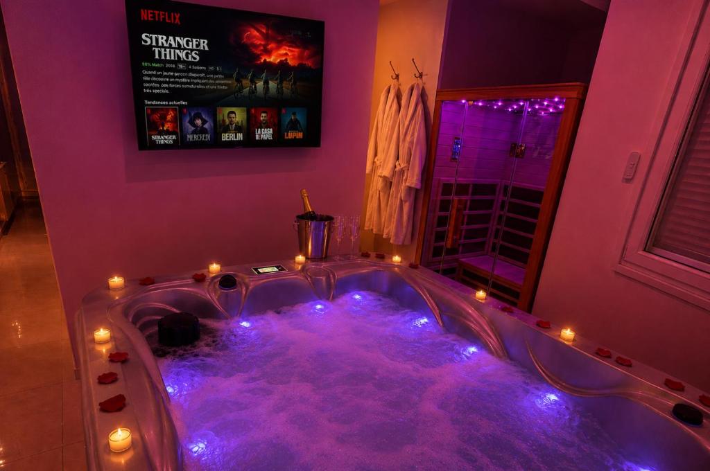 a purple bathroom with a tub with lights in it at Eaux Spa in Rouen