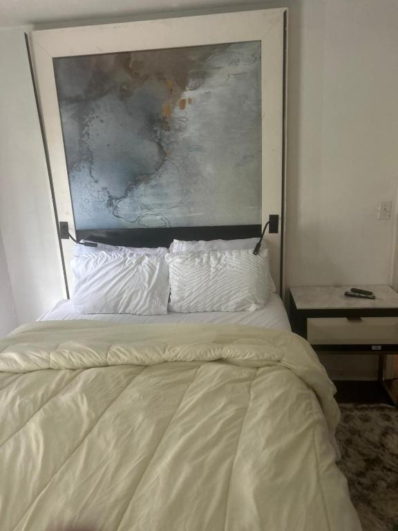 a bed in a bedroom with a painting above it at QueenRoom1 in Ellenwood