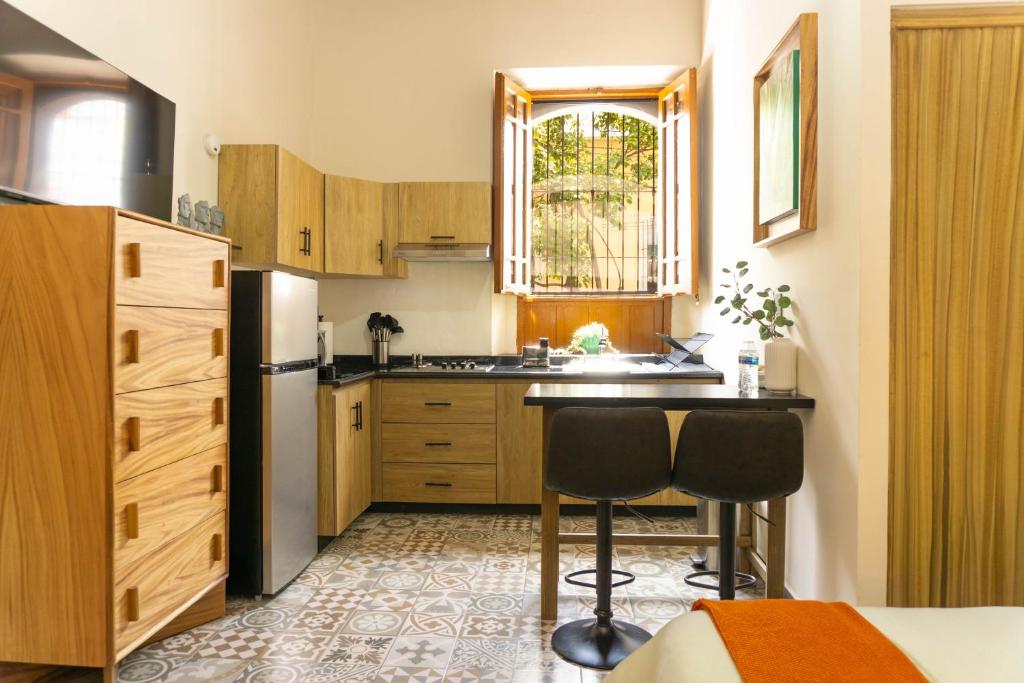 a kitchen with a refrigerator and two chairs in it at Casa del Patio in Guadalajara