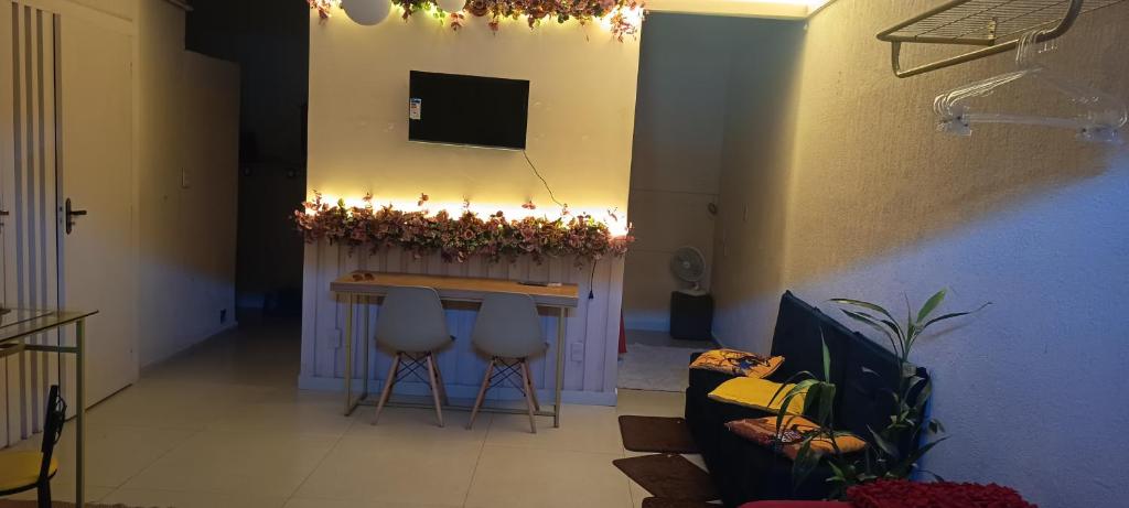 a living room with a bar with stools and a television at Espaço Jk in Diamantina