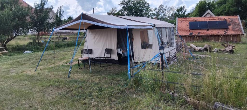 a tent in a field next to a house at DDR Klapfix Camptourist in Sandau