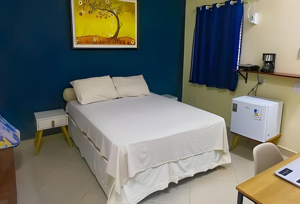 a bedroom with a white bed in a blue room at Casa Marajoara in Soure