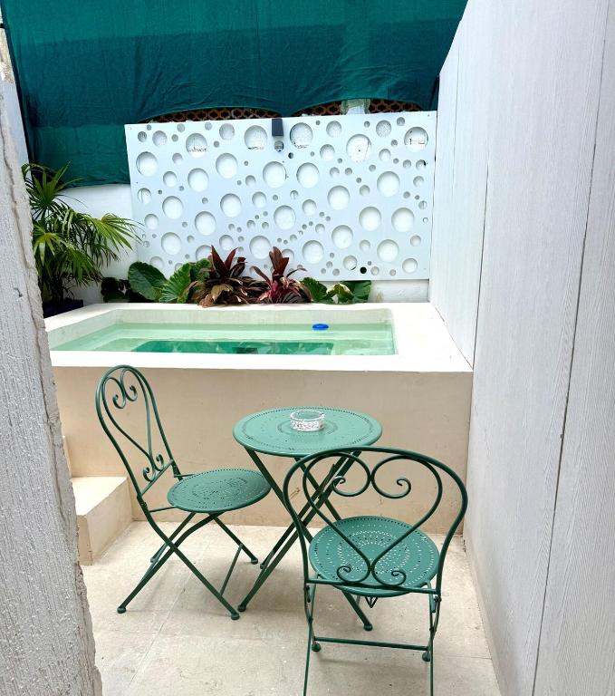 a table and two chairs next to a swimming pool at Sakna Mérida con jacuzzi alberca privada in Mérida