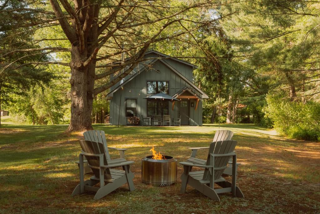 two chairs and a fire pit in front of a house at Lakefront with Private Dock & Canoe Kenoza Den in Jeffersonville